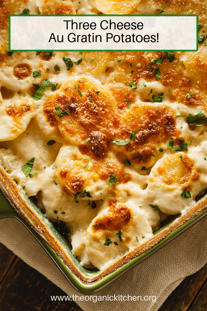 Three Cheese au Gratin Potatoes garnished with chives in green casserole dish