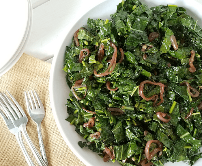 A white bowl of kale salad with shallots on white table: 12 Healthy Whole 30 Vegetable Side Dishes! 