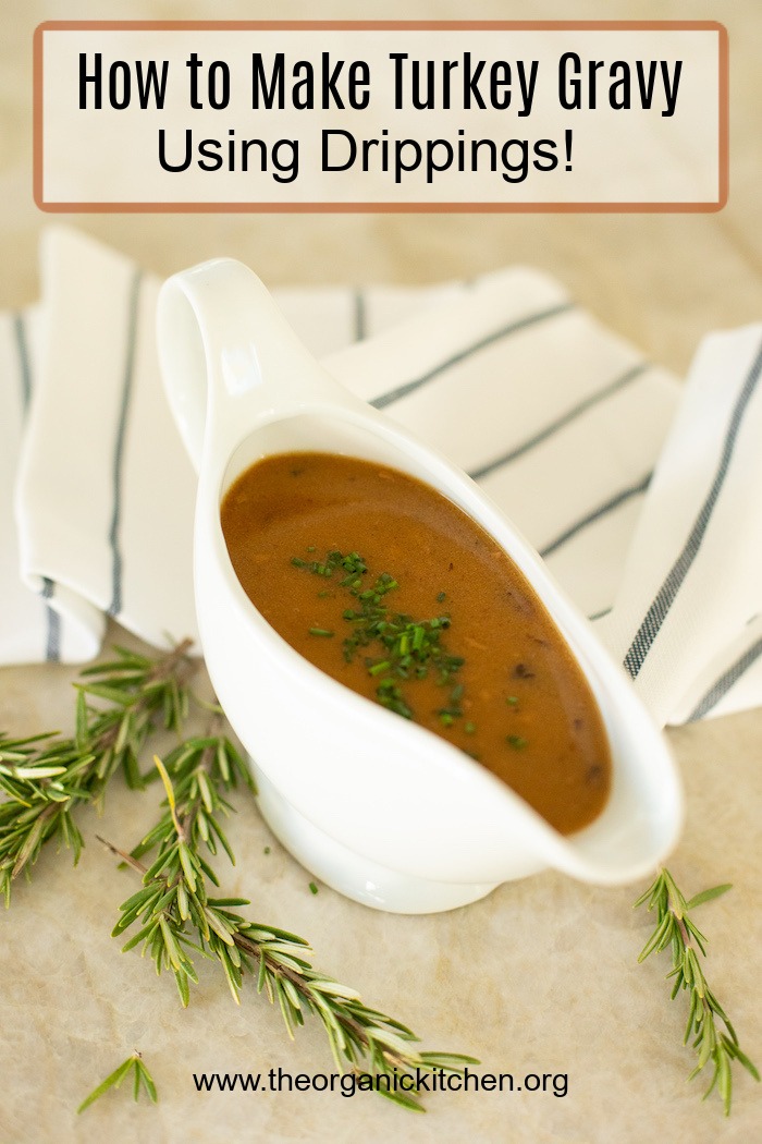 A gravy boat full of rich brown gravy surrounded by rosemary sprigs: How to Make Turkey Gravy with Drippings 