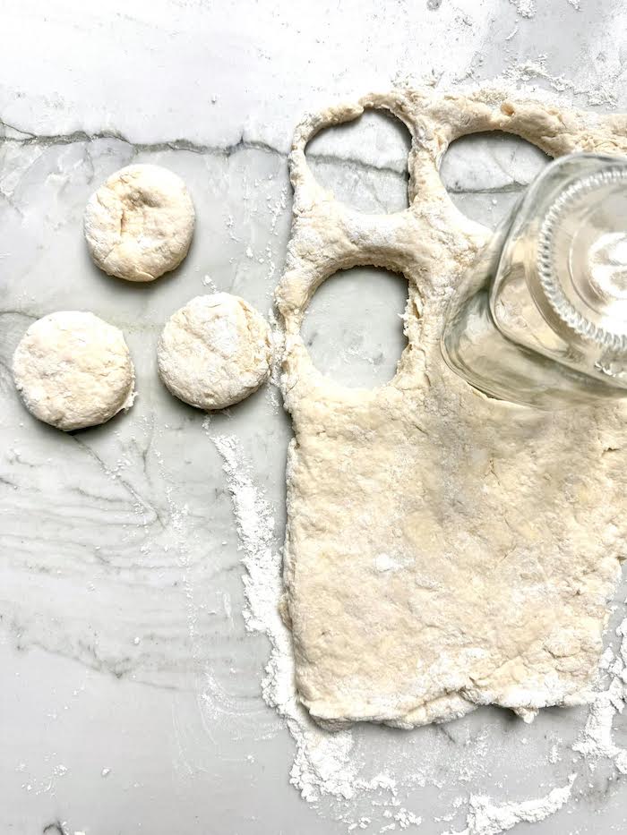 Biscuit dough being formed into biscuits by using the top of a jar