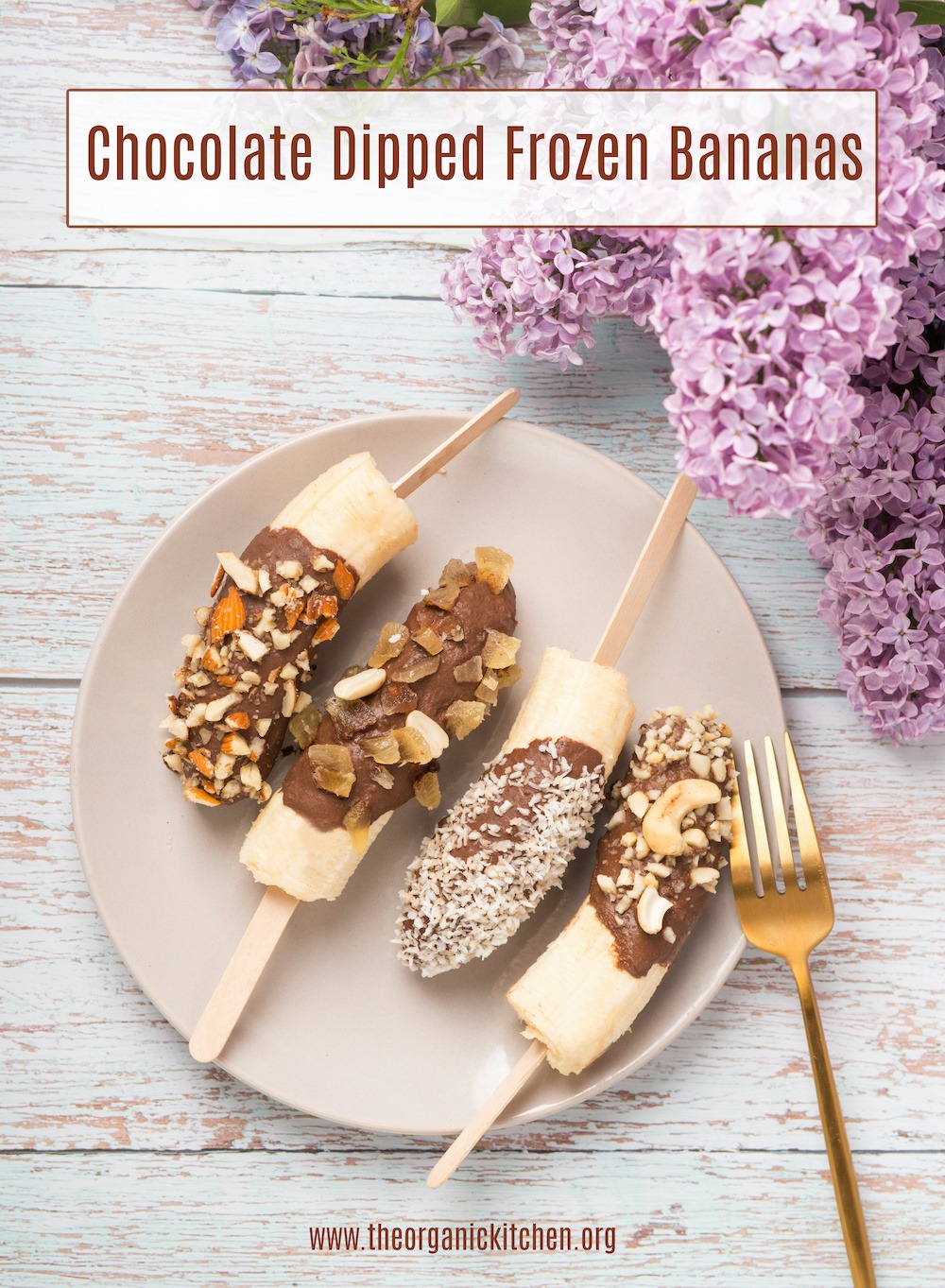 Chocolate Dipped Frozen Bananas surrounded by lilacs on white table