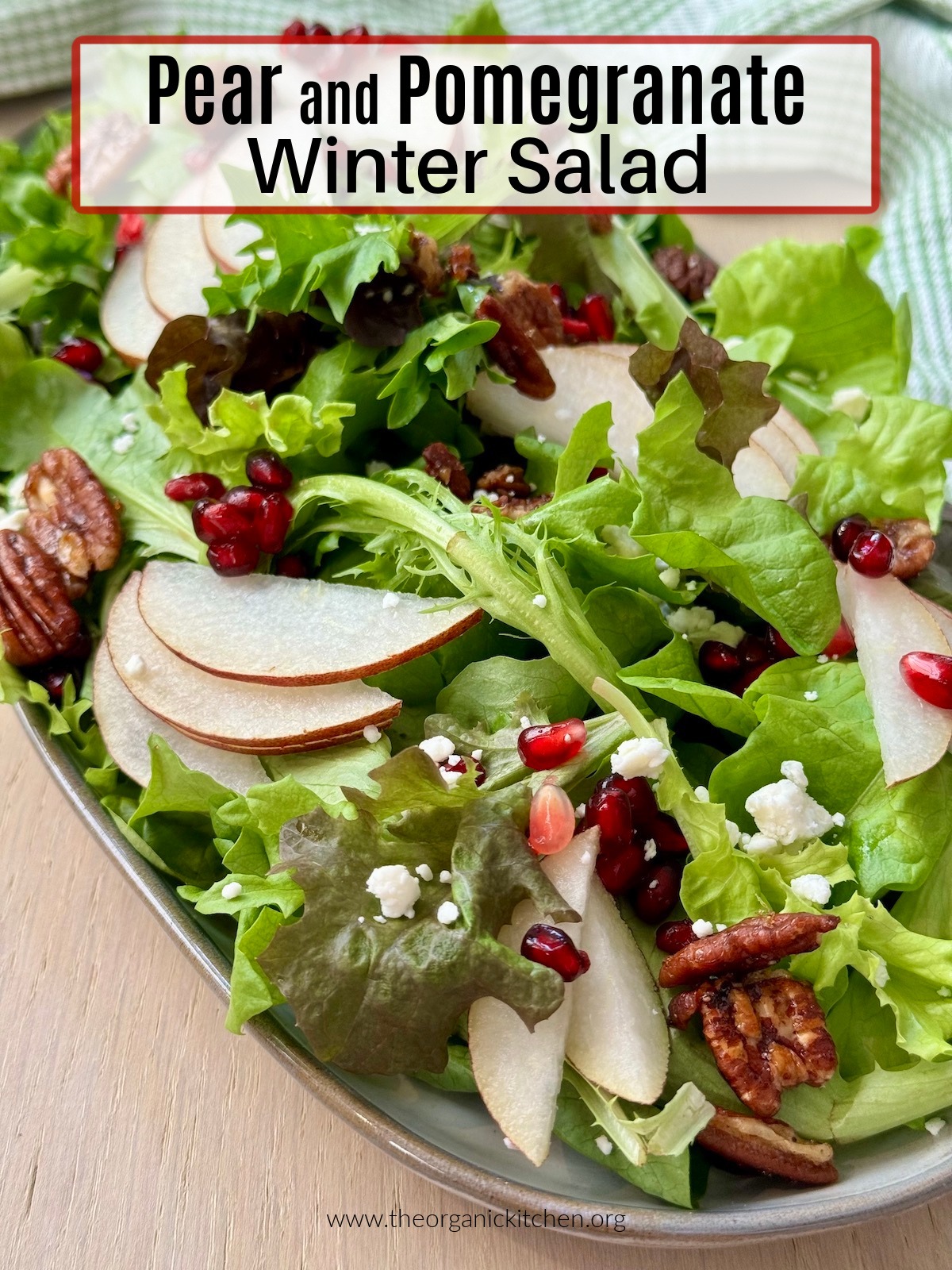 Pear and Pomegranate Winter Salad garnished with maple pecans and feta on grey platter