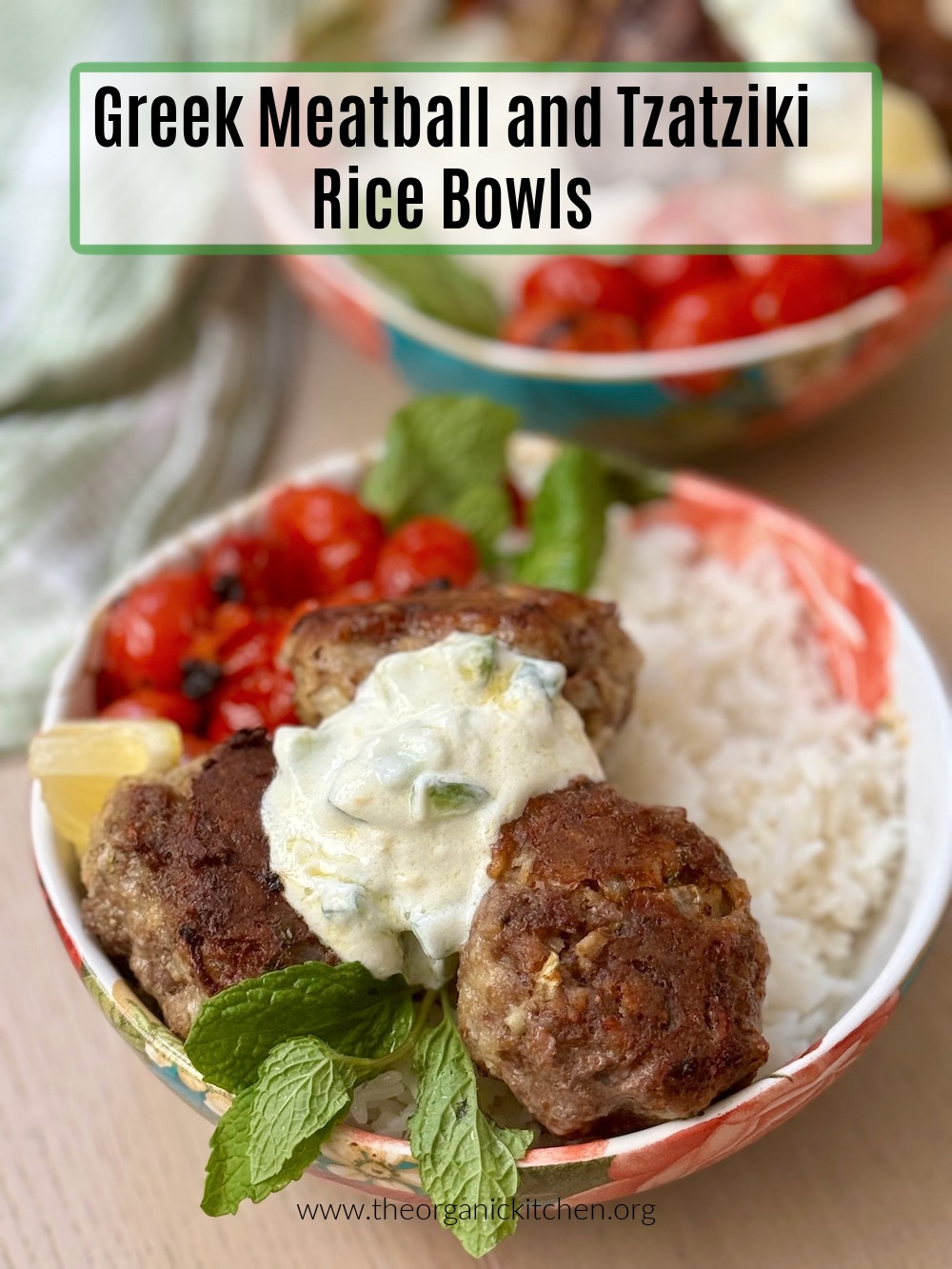 Two Greek Meatball and Tzatziki Rice Bowls garnished with mint and lemon wedges