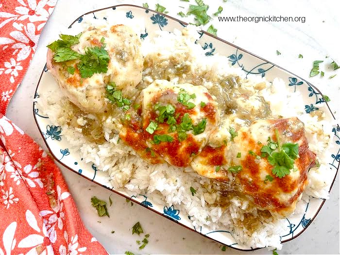 A blue and white platter with Easy Chicken Salsa Verde served over rrice and garnished with herbs